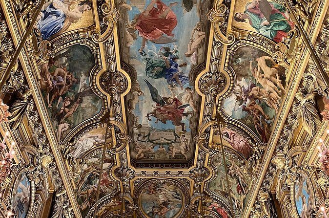 Painted figures and gilded ribs on a ceiling inside the Palais Garnier